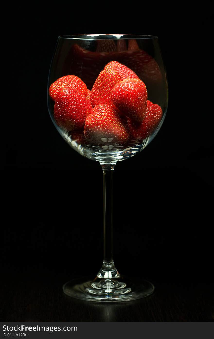 Strawberry in glass on black background