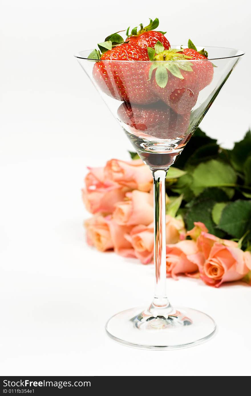 Romantic rose with strawberries in glass over white