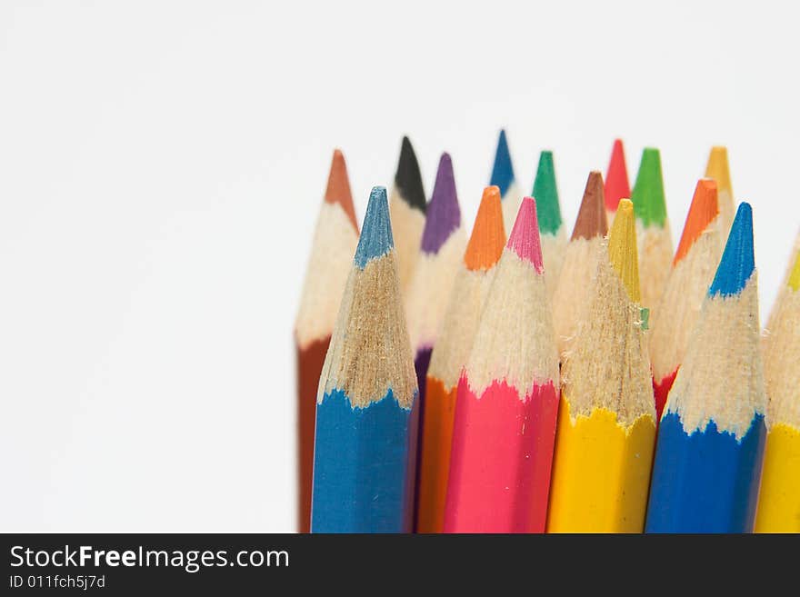 Upright colored wooden crayons on white background. Upright colored wooden crayons on white background