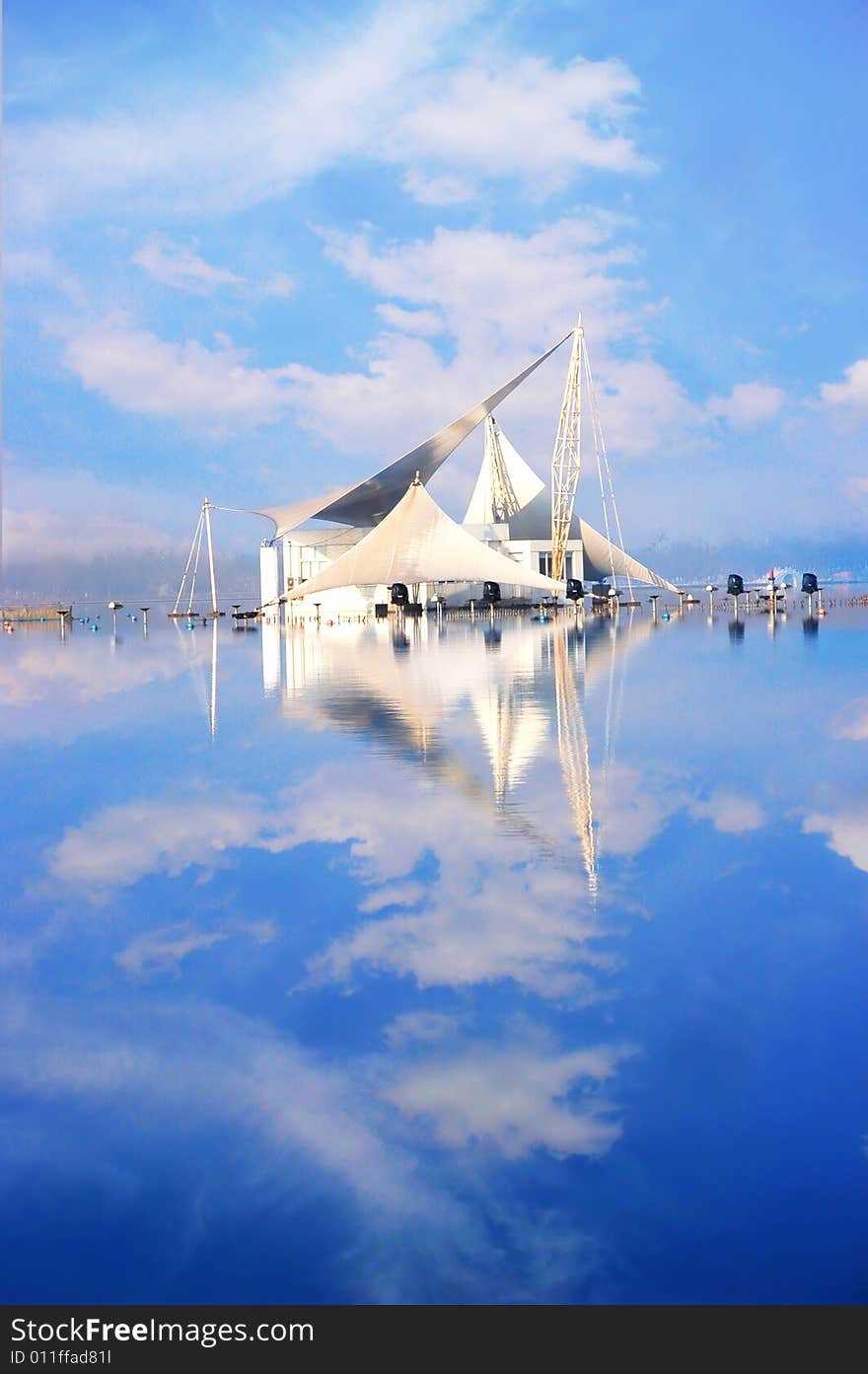 The modern building by the side of a lake .