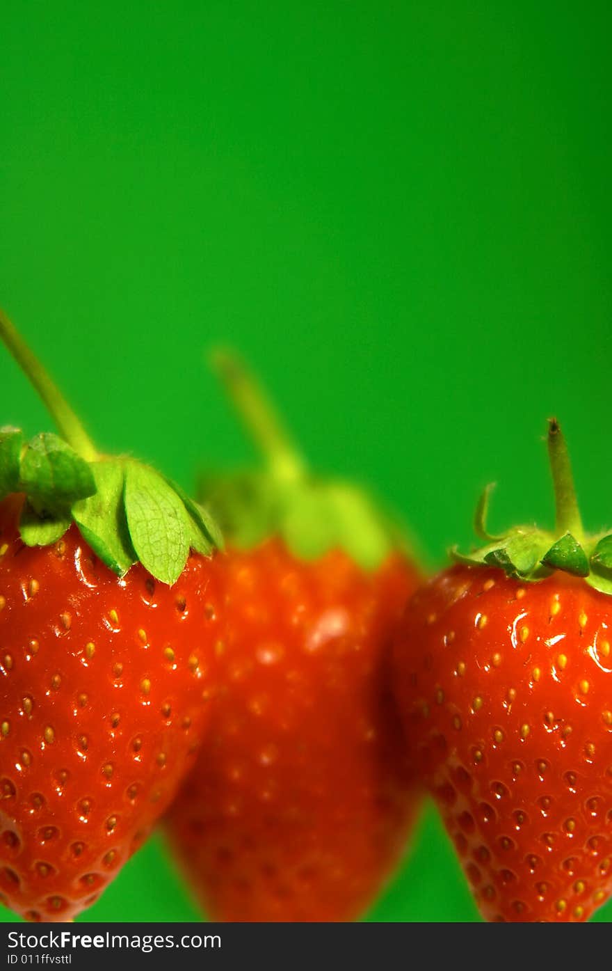 Close-up of strawberries in line on green background. Close-up of strawberries in line on green background