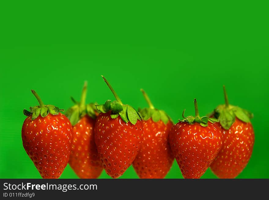 Strawberries in line on green background. Strawberries in line on green background