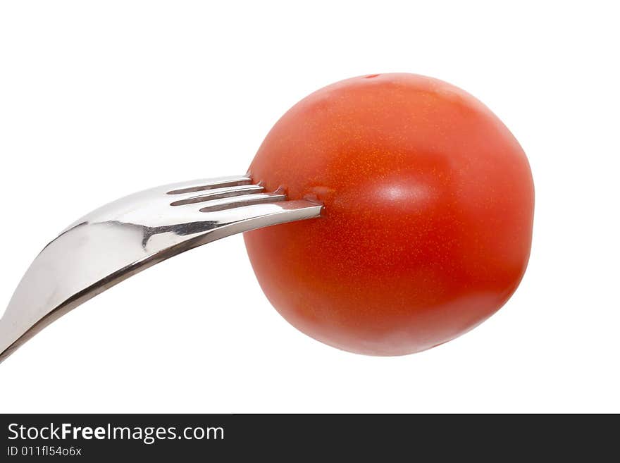 A tomato on a fork isolated on white