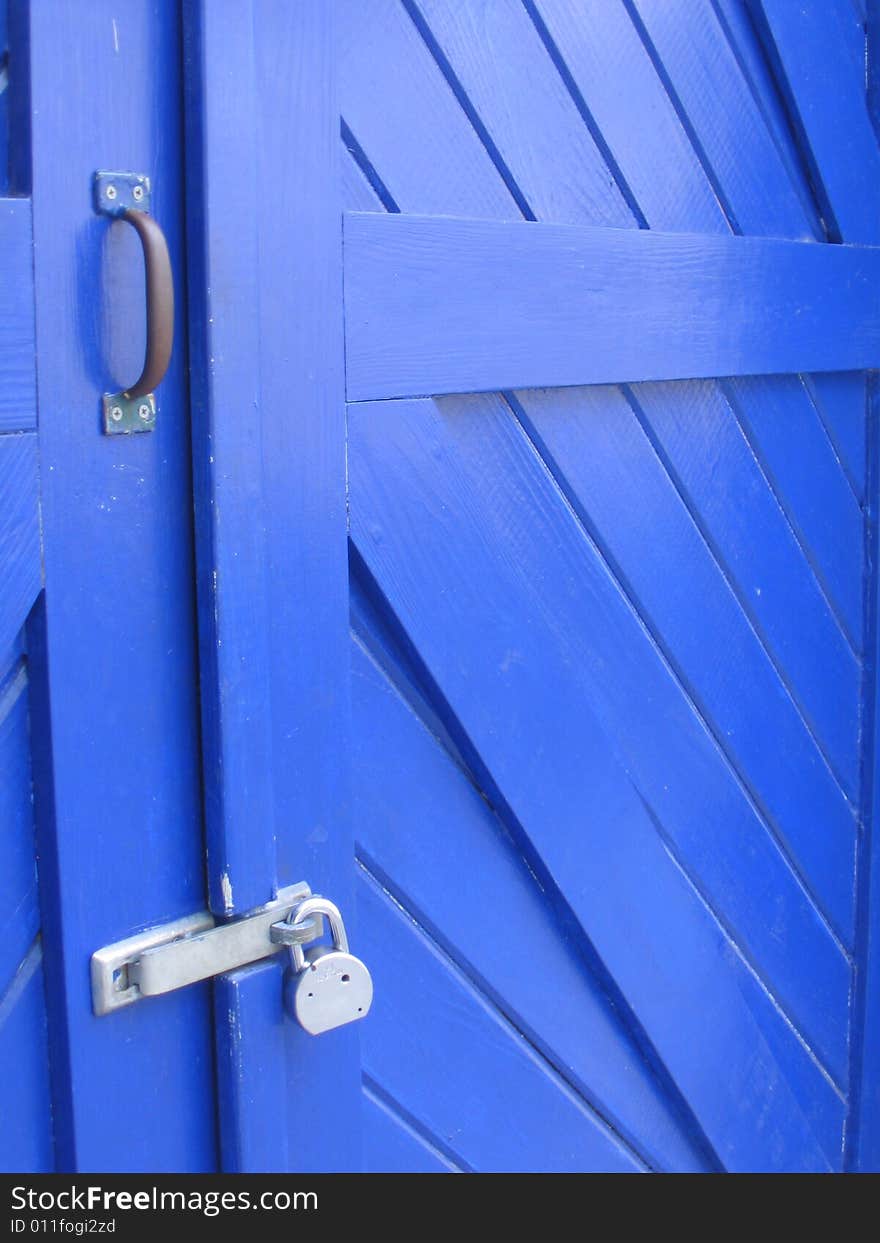 Blue, wooden, padlocked door in Key West