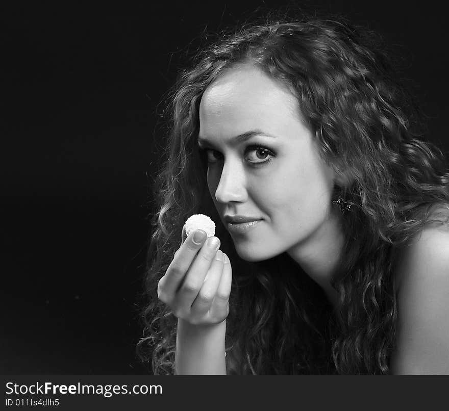 A young girl holds the unfolded white candy in a hand. A young girl holds the unfolded white candy in a hand