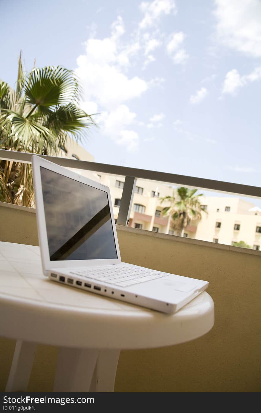 Workplace in hotel balcony with palm tree in background