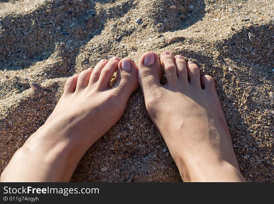 Image of the feet of a female lying in the sand. Image of the feet of a female lying in the sand