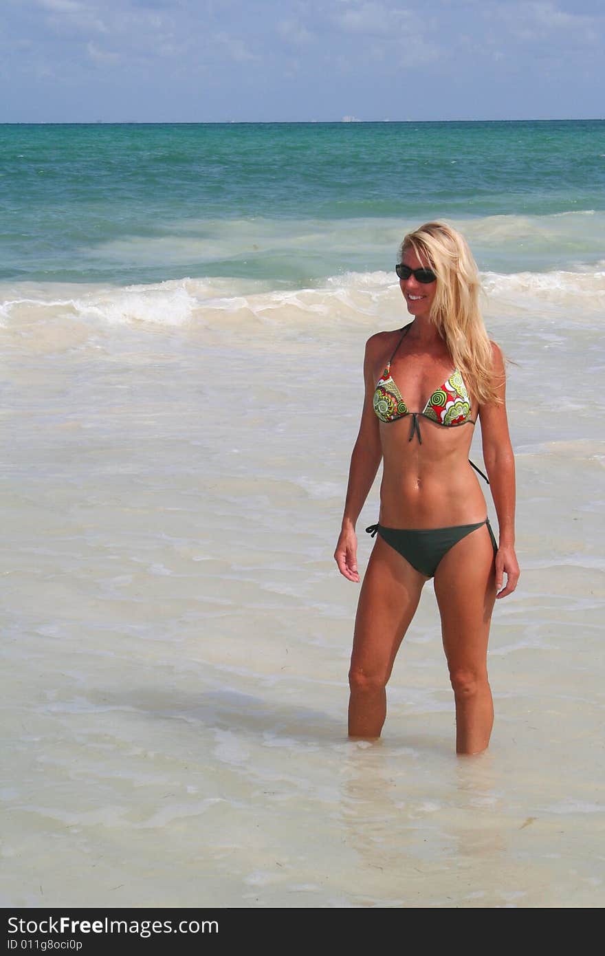 Sexy blonde woman in bikini wading in the ocean. Sexy blonde woman in bikini wading in the ocean