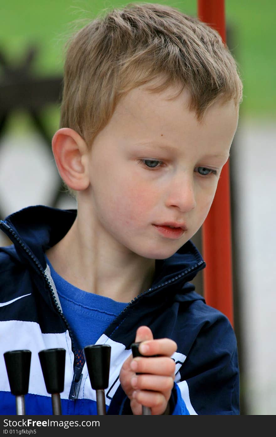 Young boy playing with the controls of a toy in a park. Young boy playing with the controls of a toy in a park