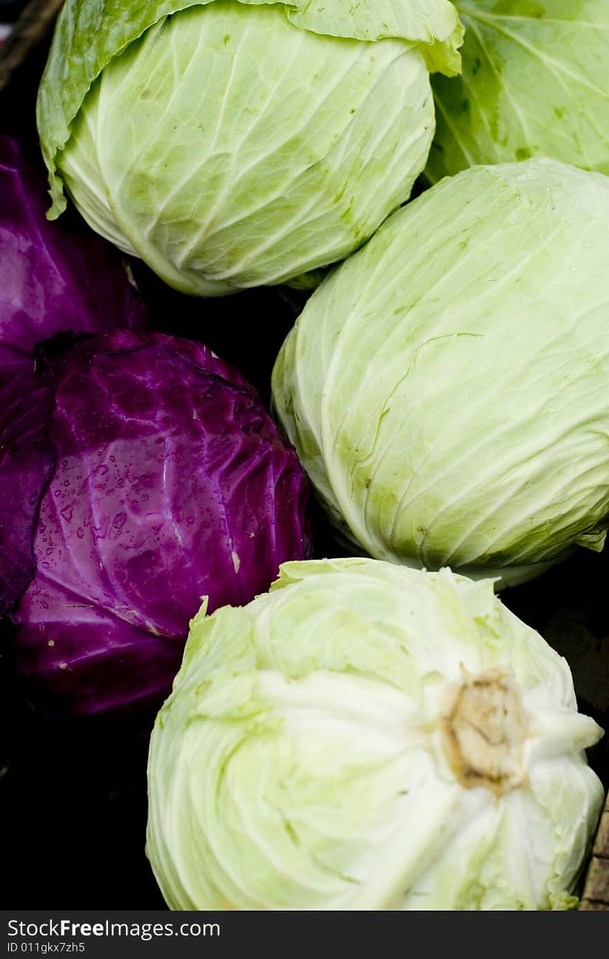 A batch of green and purple cabbage at a local market. A batch of green and purple cabbage at a local market.