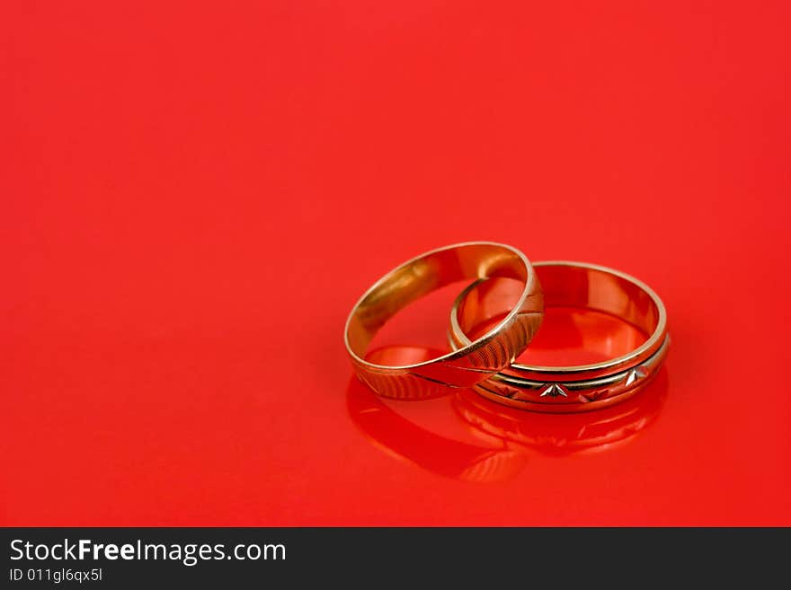 Gold wedding rings on red background