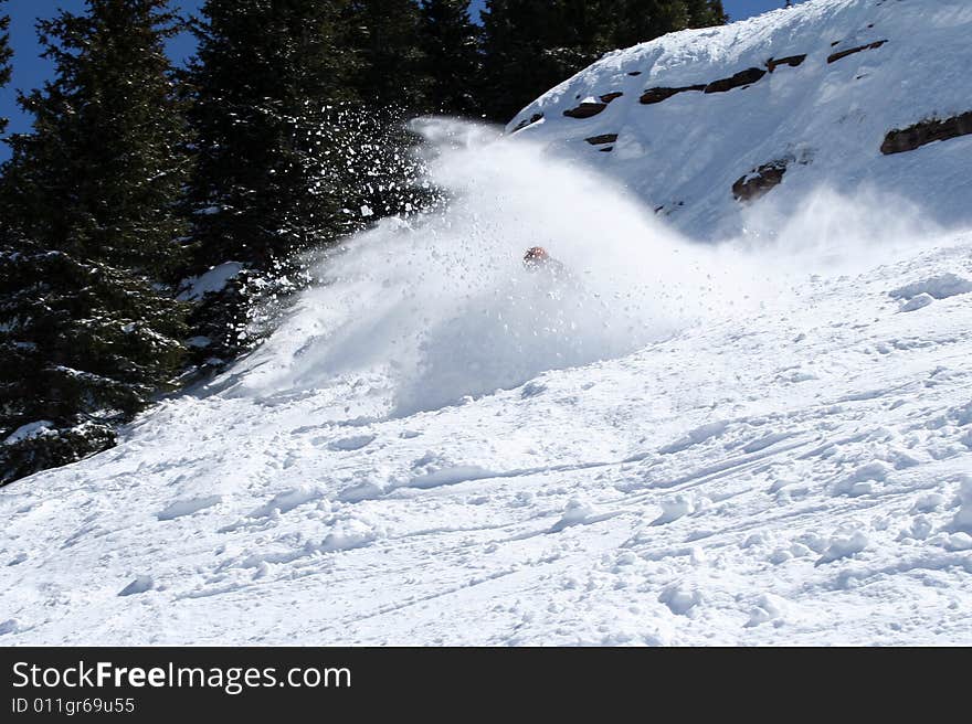 A rider falls down in the snow on a great powder day, after a big jump. A rider falls down in the snow on a great powder day, after a big jump