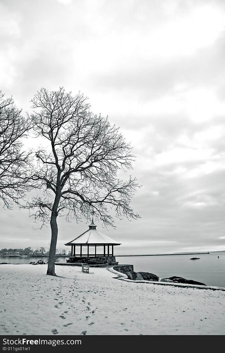 Portrait view of shoreline in winter with gazebo and trees. Portrait view of shoreline in winter with gazebo and trees.