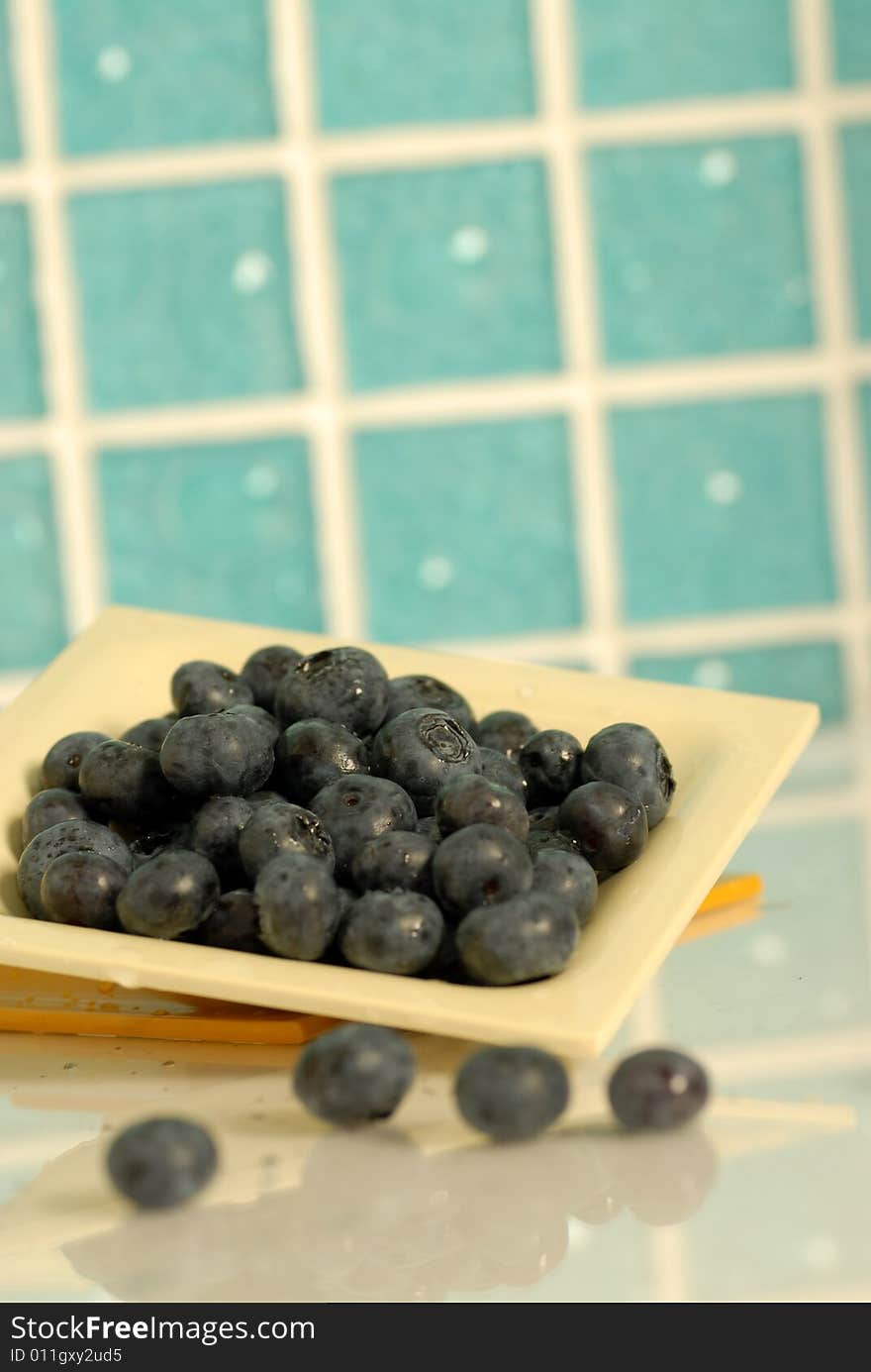 Blueberries against blue tiles background. Blueberries against blue tiles background