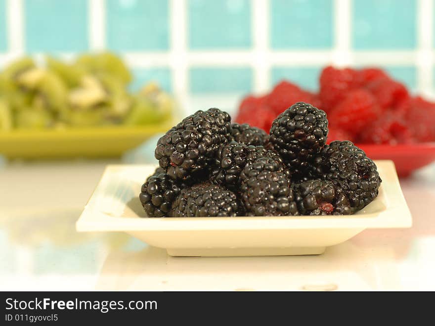 Blackberries against blur raspberries and kiwi background. Blackberries against blur raspberries and kiwi background