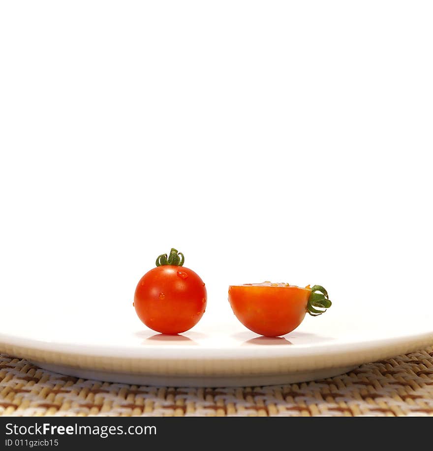 Ripe tomato on a plate isolated on a white background. Ripe tomato on a plate isolated on a white background