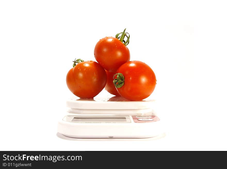 Ripe juicy tomatos and scale isolated on white