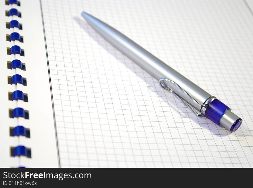 One silver pen and spiral notebook closeup