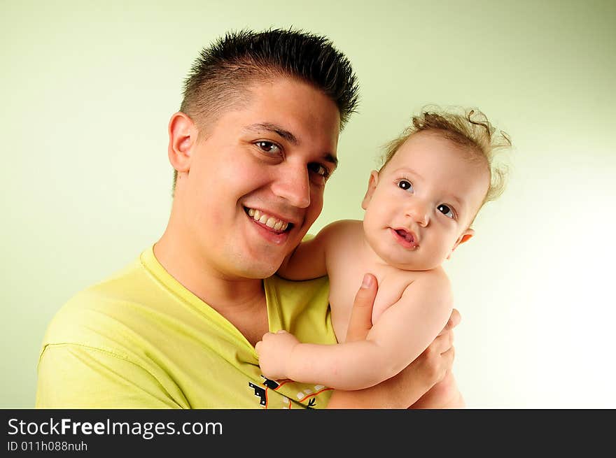 Dad and little baby boy over green background