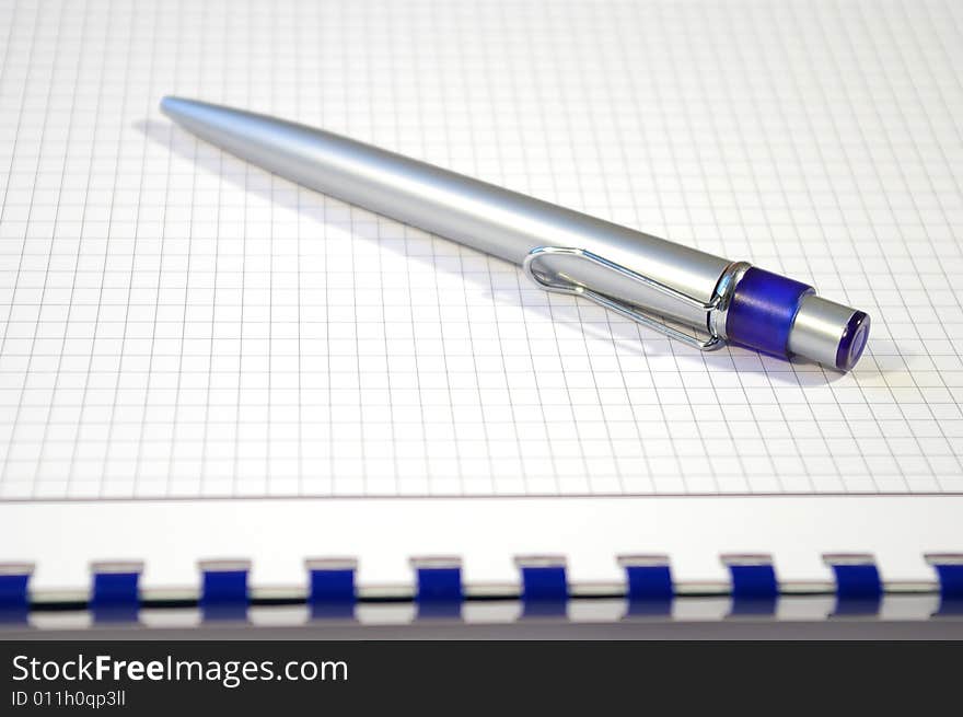 One silver pen and spiral notebook closeup