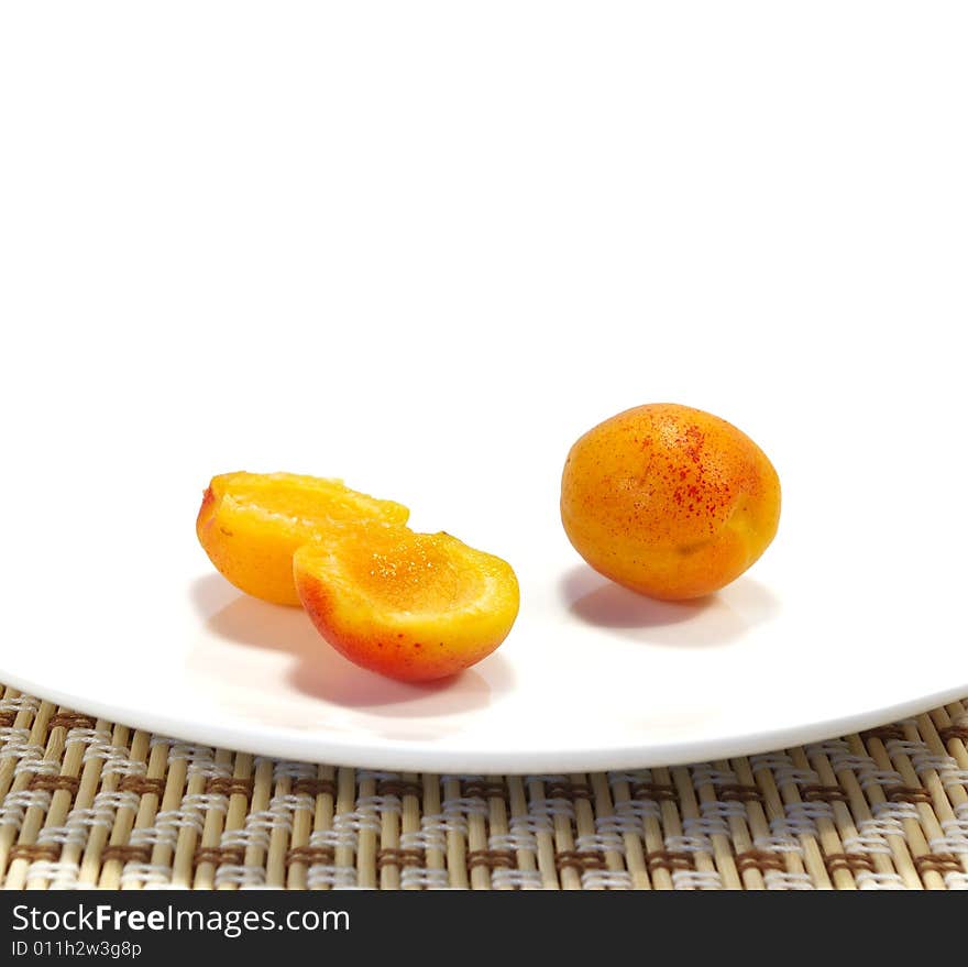 Ripe sweet apricots on a white plate