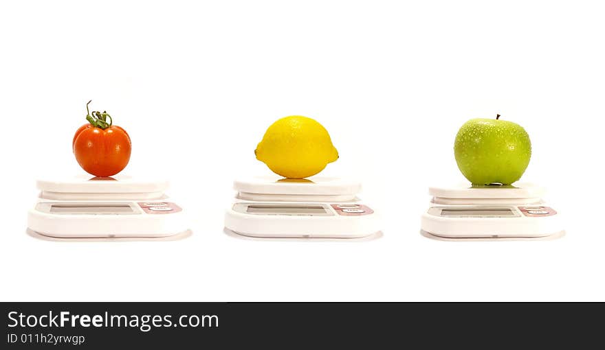 Apple, lemon and tomato on the scale isolated. Apple, lemon and tomato on the scale isolated