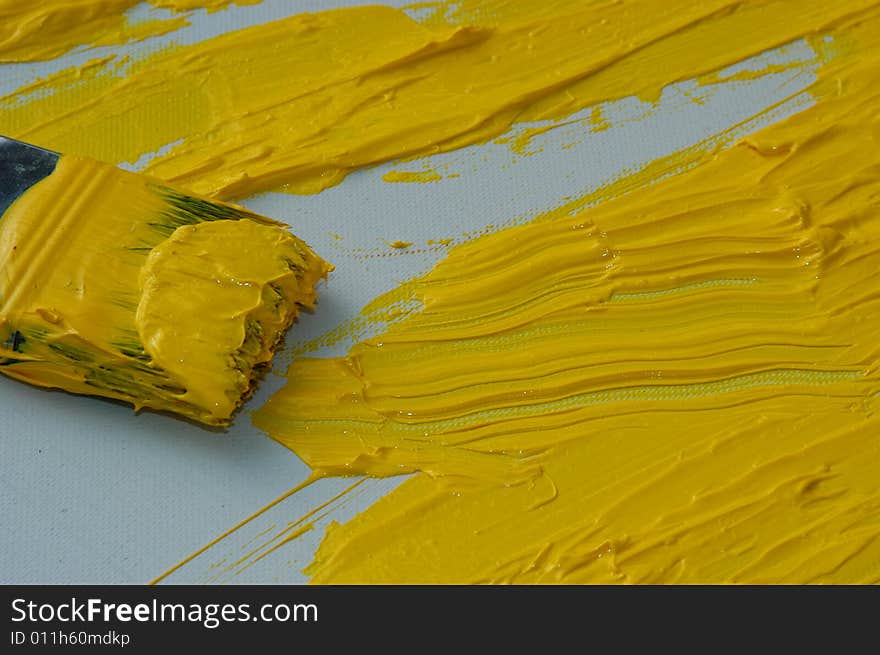 Yellow color on a brush, art painter studio