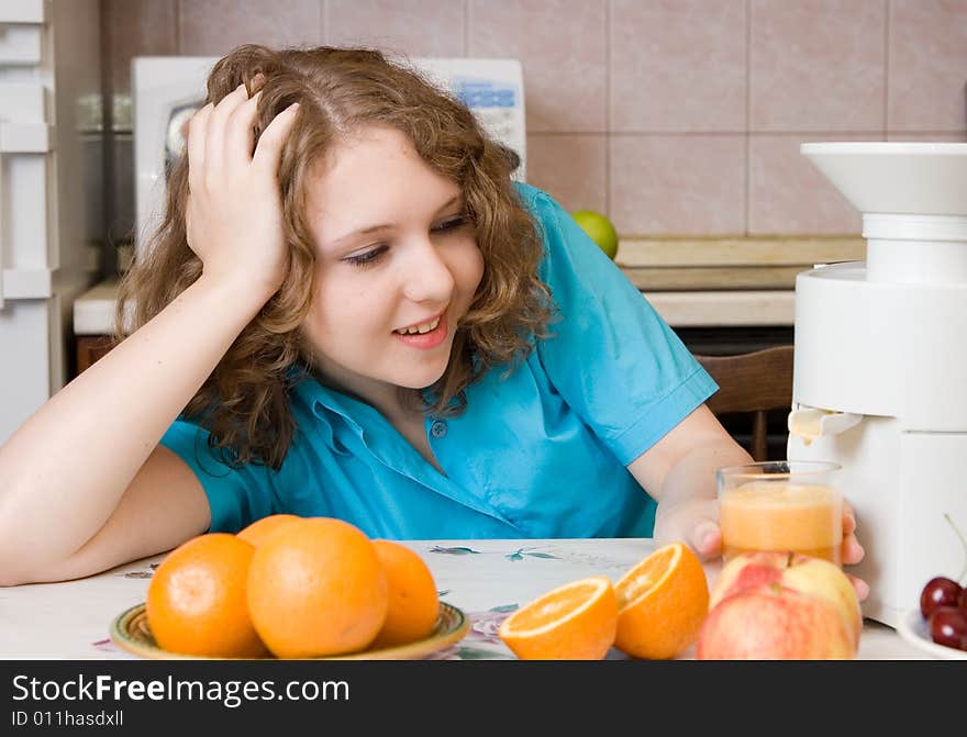 Smiling girl with blender and fruits on home kitchen