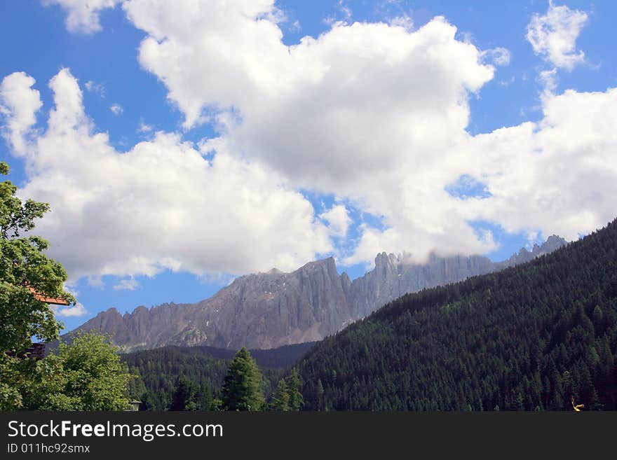 Sella mountain group  on blue cloudy sky, green valley and forest. Italy. Sella mountain group  on blue cloudy sky, green valley and forest. Italy