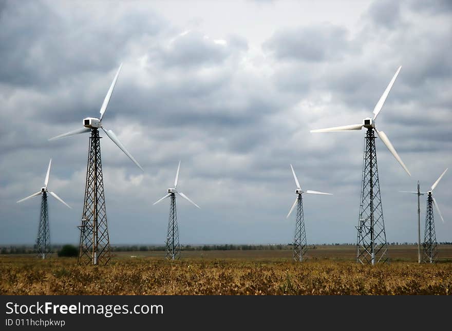 Group of wind turbines over sky background