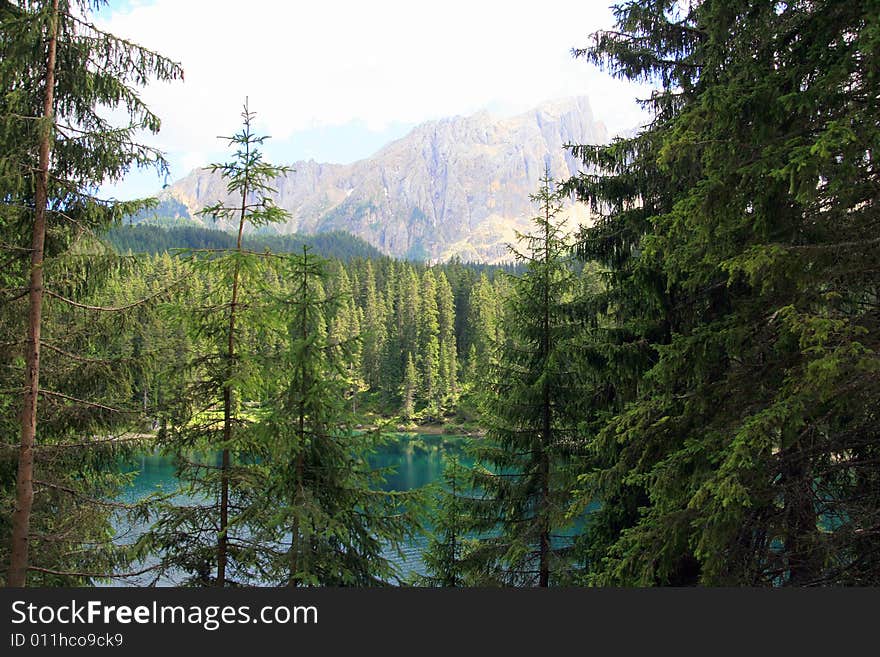 Sella montain group, green valley and woods. carezza lake water tourquoise colours. Italy. Sella montain group, green valley and woods. carezza lake water tourquoise colours. Italy