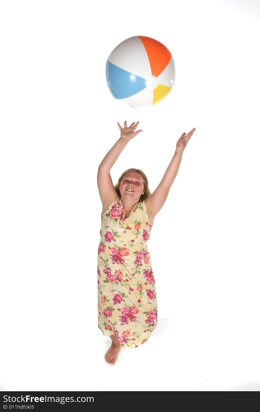 Heavy set girl in dress catching a beach ball. Heavy set girl in dress catching a beach ball