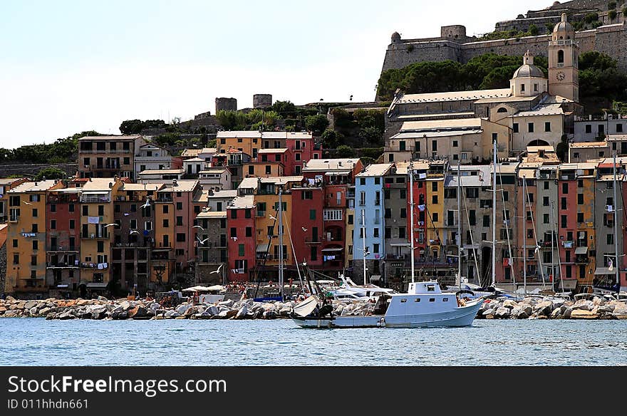 Fishing boats on a harbor with the seafront view of Portovenere in Italy.