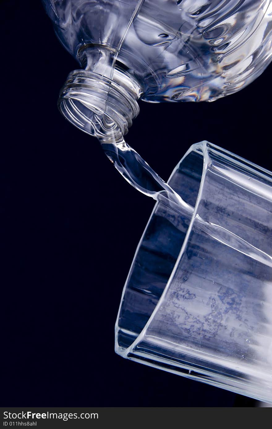 Water flowing from bottle to glass. Water flowing from bottle to glass