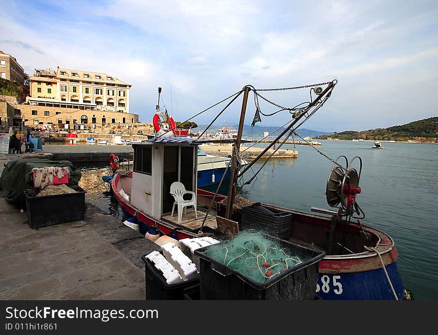 Fishing boats on a harbor with the seafront view of Portovenere in Italy.