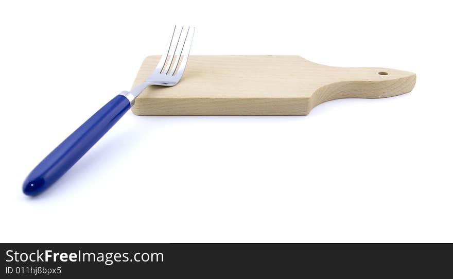 Metal fork and wooden board on white background