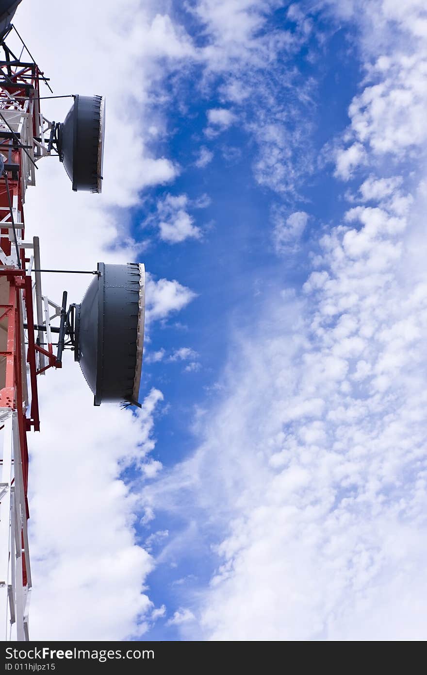 Telecommunication antenna under clouded sky.