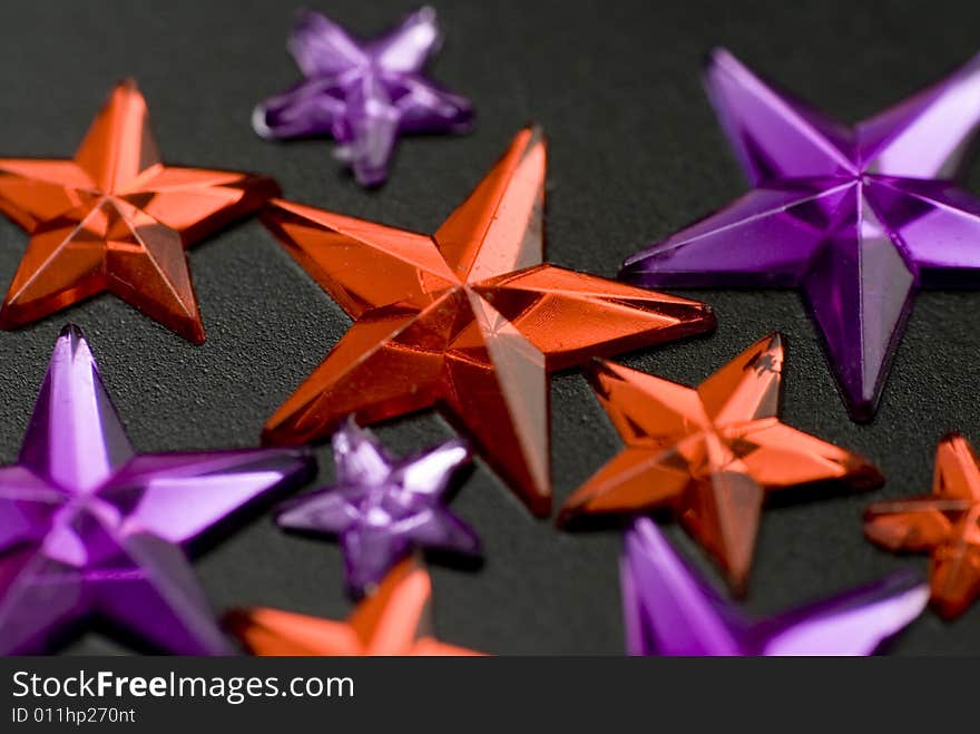 Red and purple christmas stars on black background