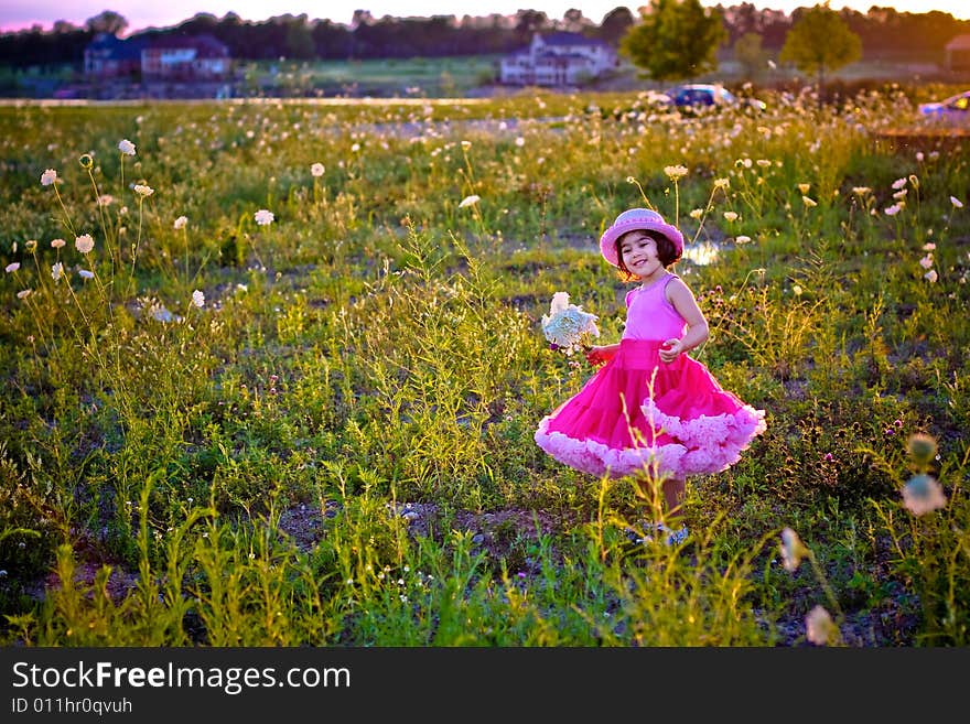 Child in a flower field wearing a cute pettiskirt and rose pink hat