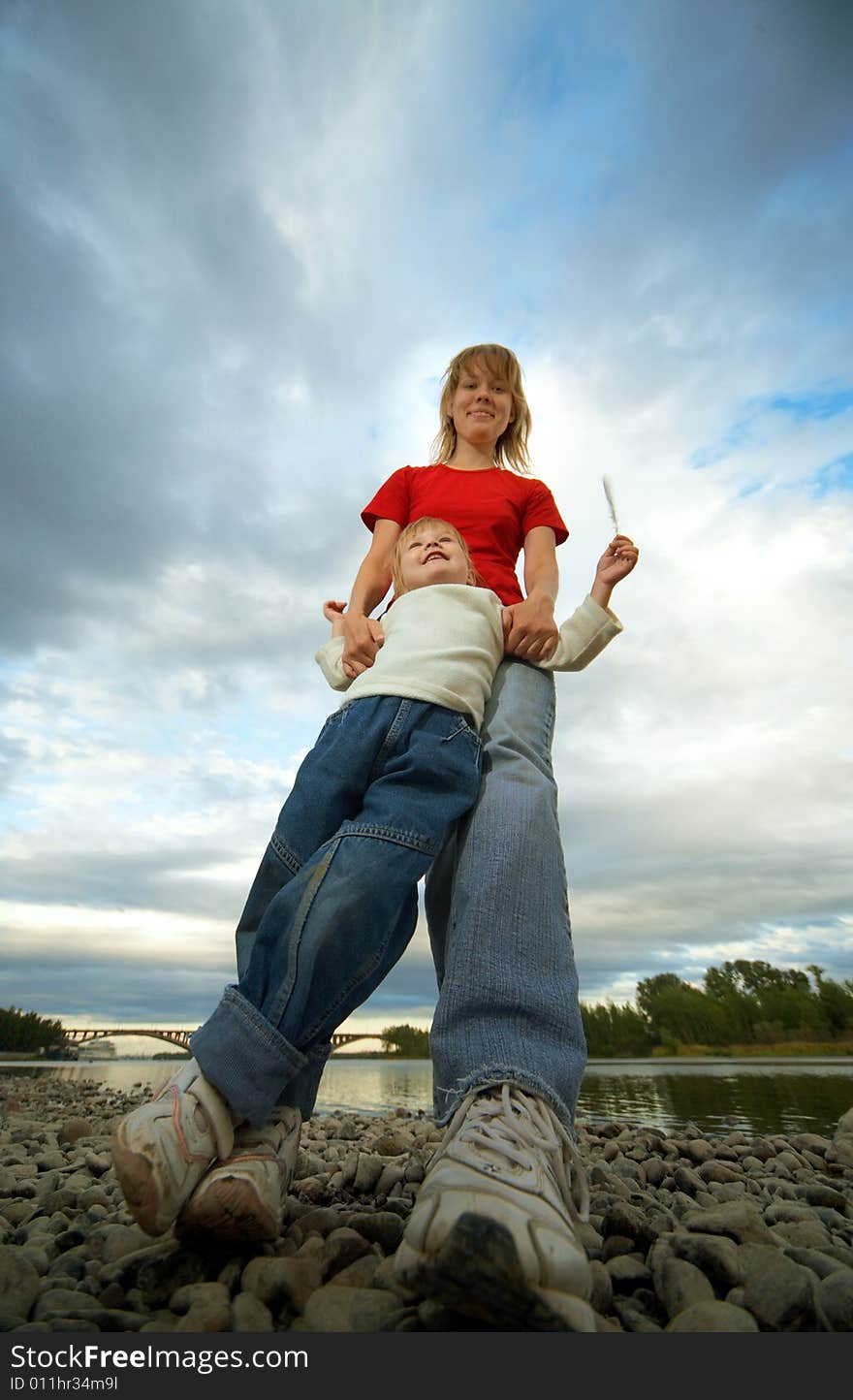 Mother and child outdoor on stones and river