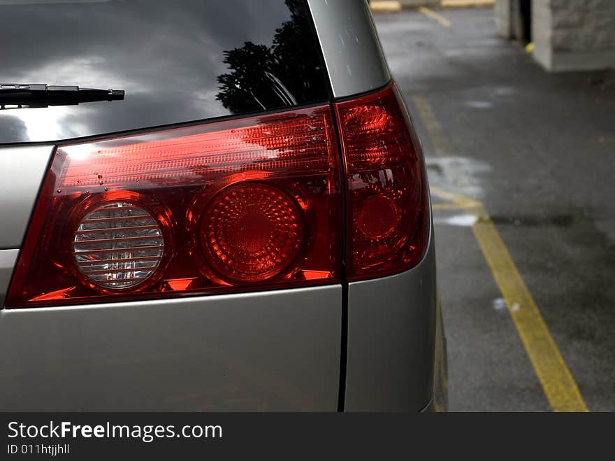 Close up of a red passenger side tail light on a parked silver car. Close up of a red passenger side tail light on a parked silver car.