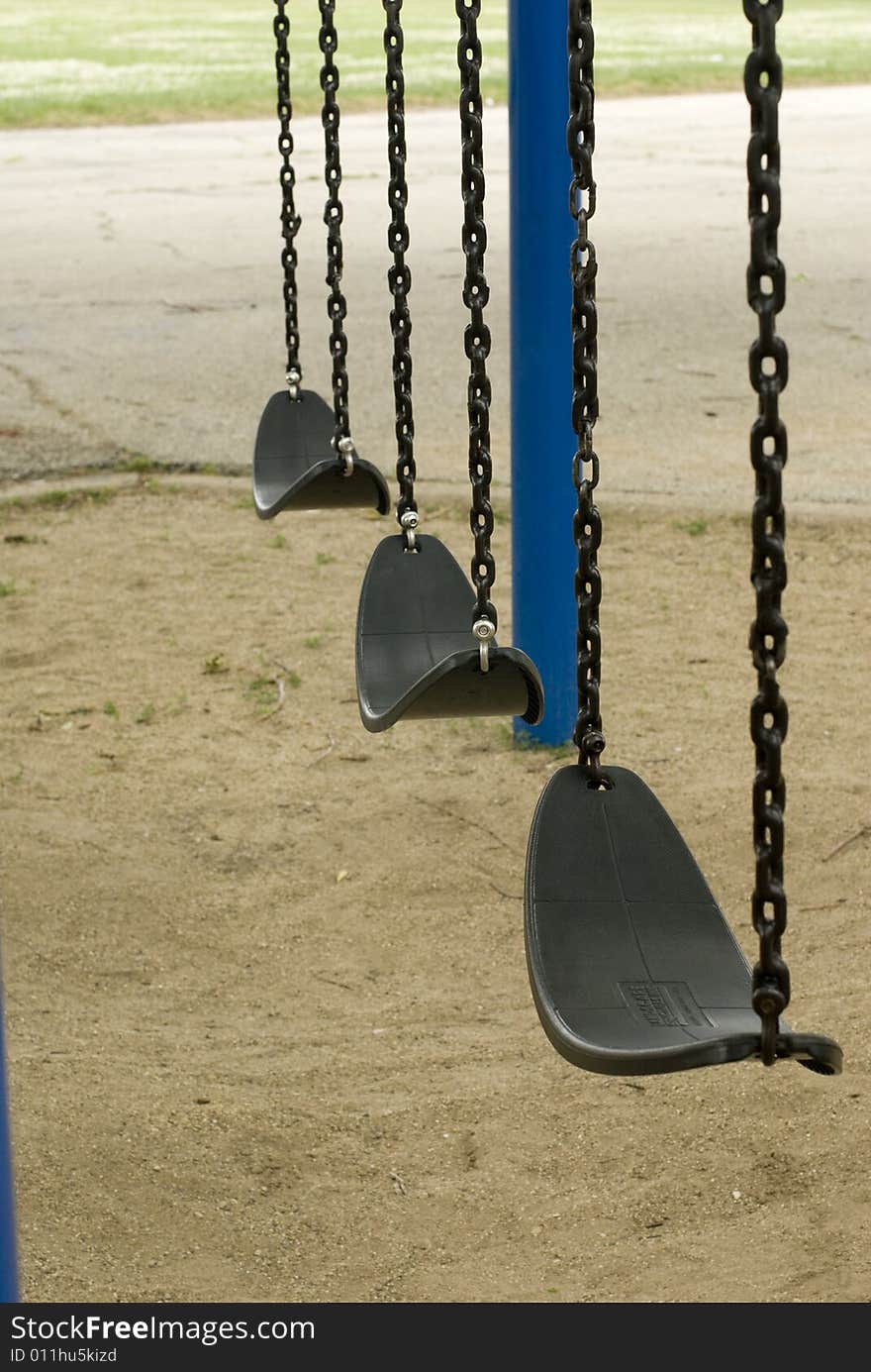 Motionless swings on a sandy playground. Motionless swings on a sandy playground.