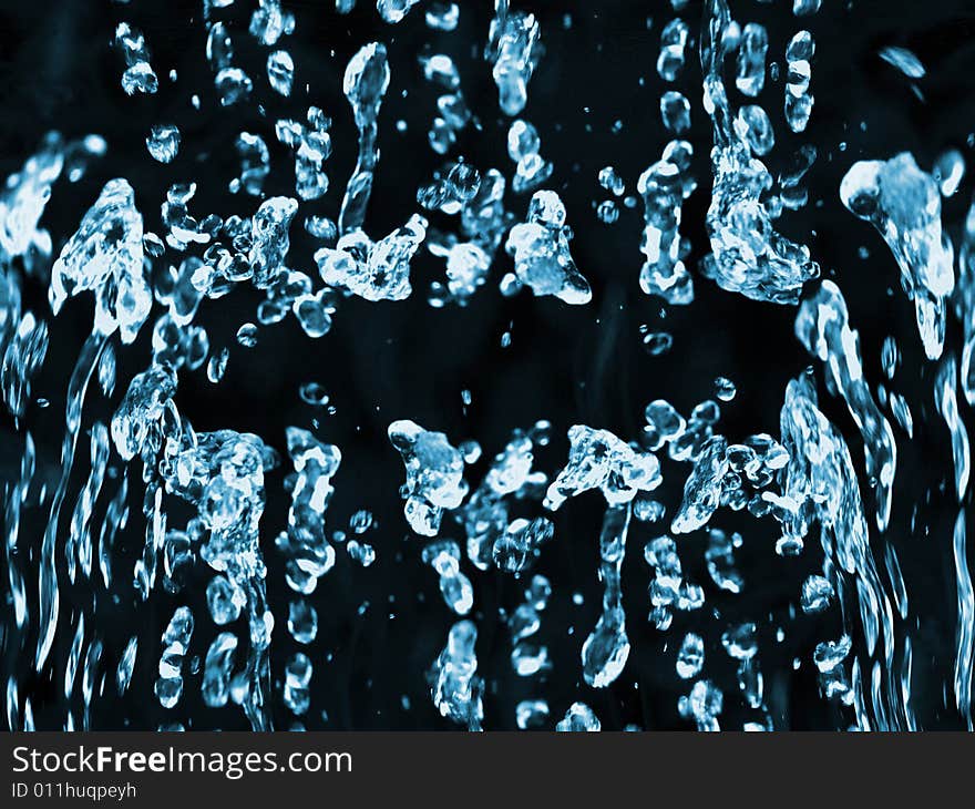 Blue water droplets against a black background