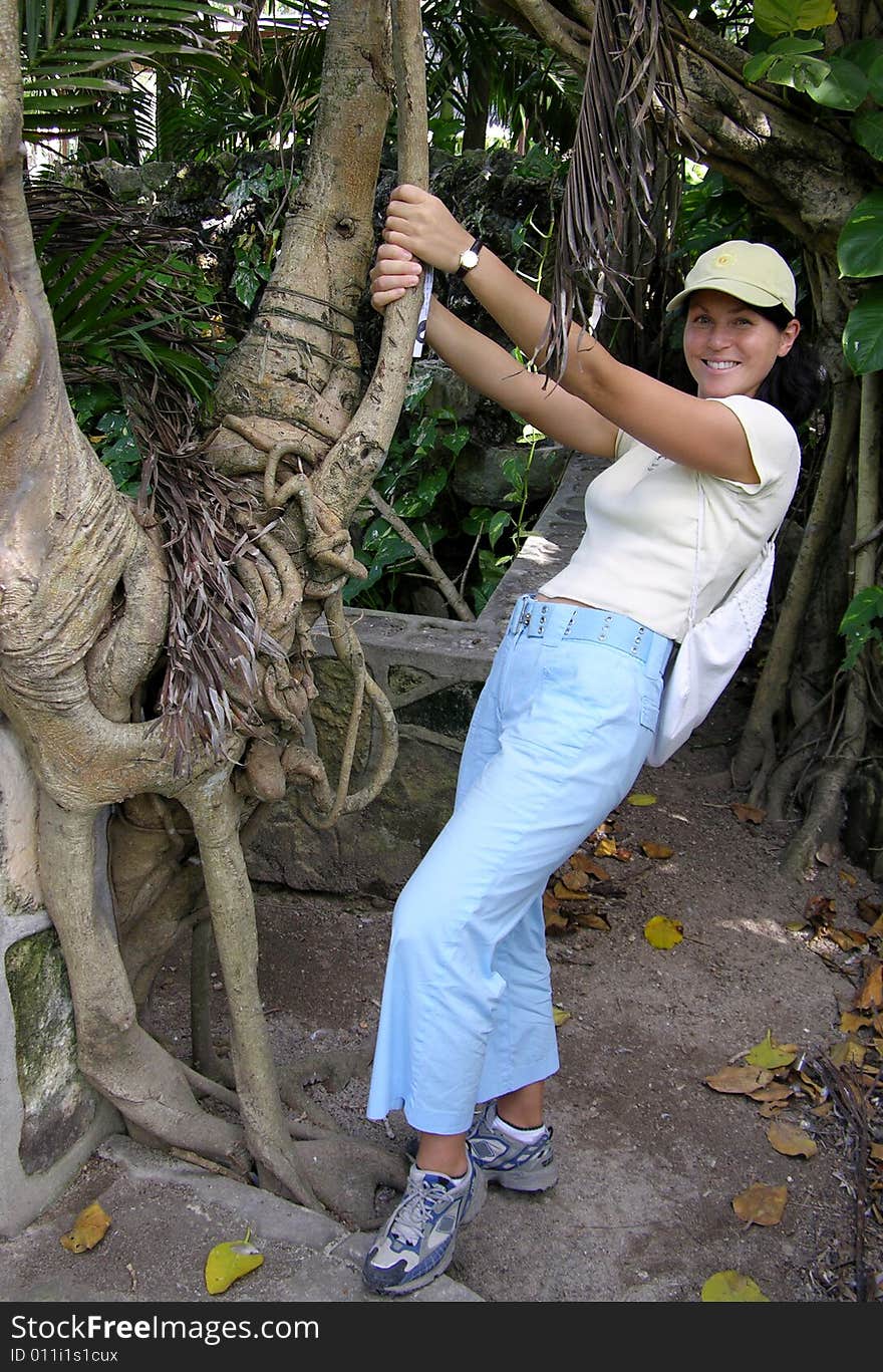 The girl near exotic roots of a tree in Nassau town botanical garden, The Bahamas. The girl near exotic roots of a tree in Nassau town botanical garden, The Bahamas.