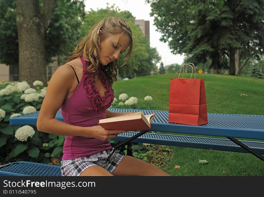 A picture of a woman reading  a book in the park. A picture of a woman reading  a book in the park