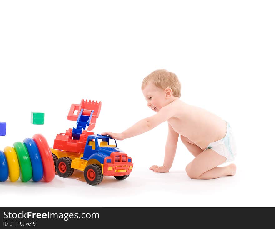 Little boys play with toy truck over white background with light shadows.