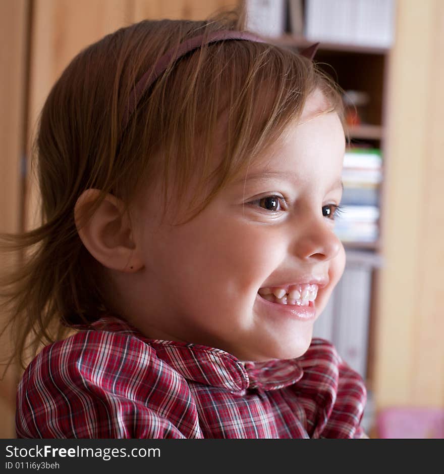 Portrait of a joyful little girl in living room