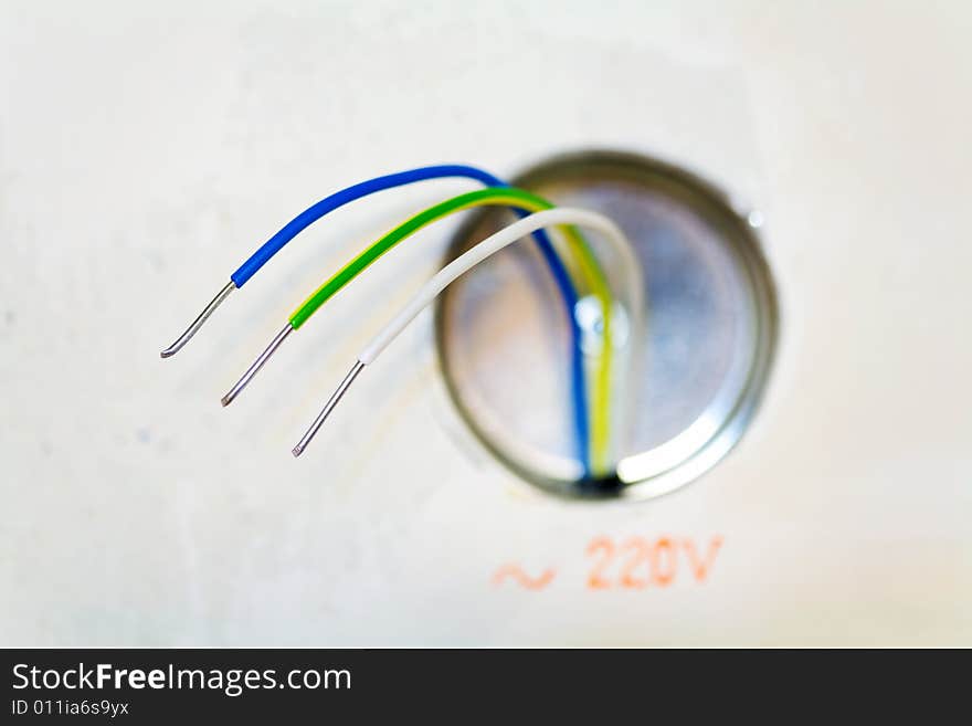 Color wires of an electric cable and terminal box, located on a plasterboard