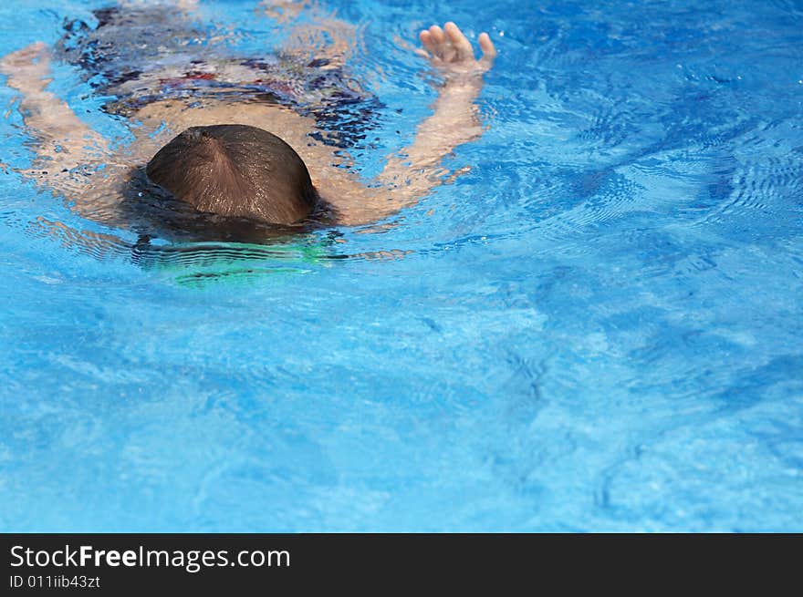 A young boy in pool with goggles on. A young boy in pool with goggles on