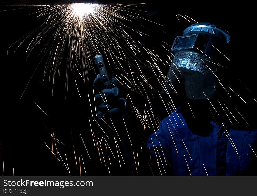 A welder working at shipyard at night. A welder working at shipyard at night